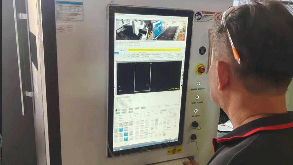 Photo of engineer viewing display screen of fiber laser cutting machine