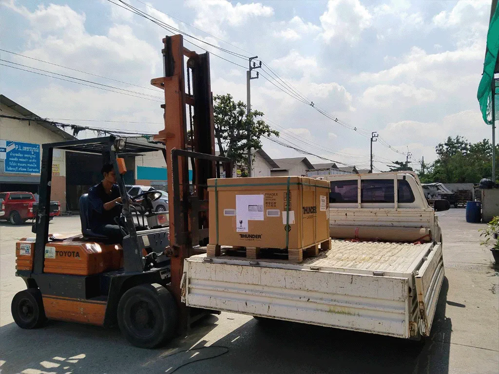 Photo of packed machine unloading from truck by forklift