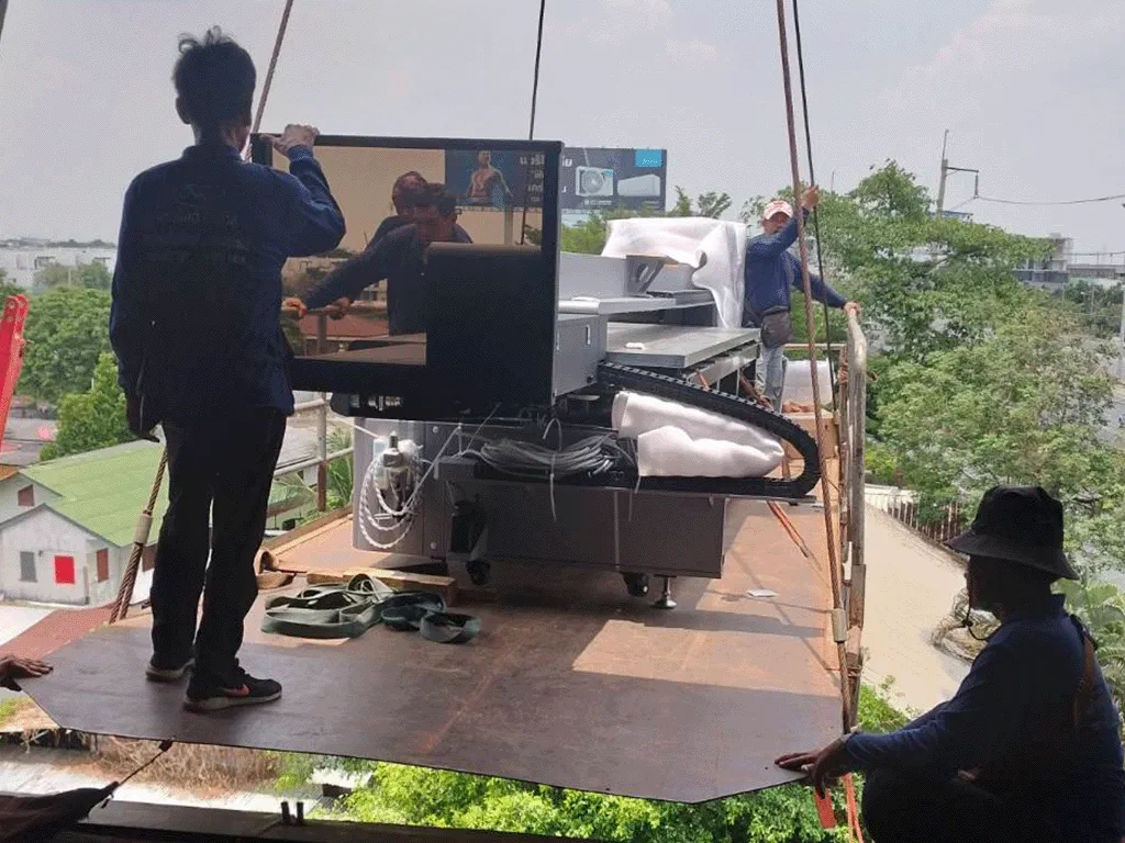 Photo of lifting massive laser machine to higher floor by crane