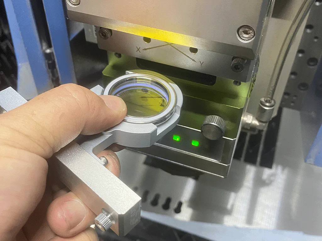 Photo of engineer holding a fiber laser focus lens